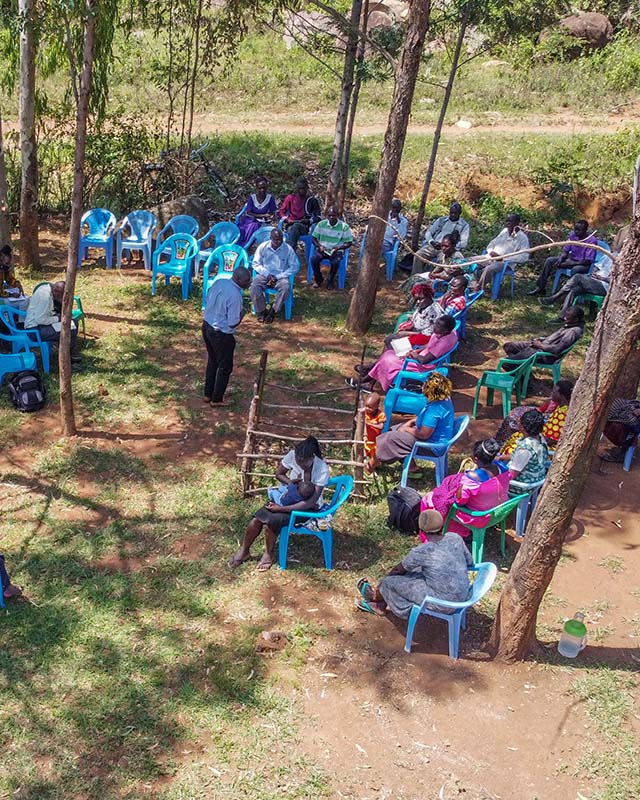 The group gathered in the shade of the trees for the theory.